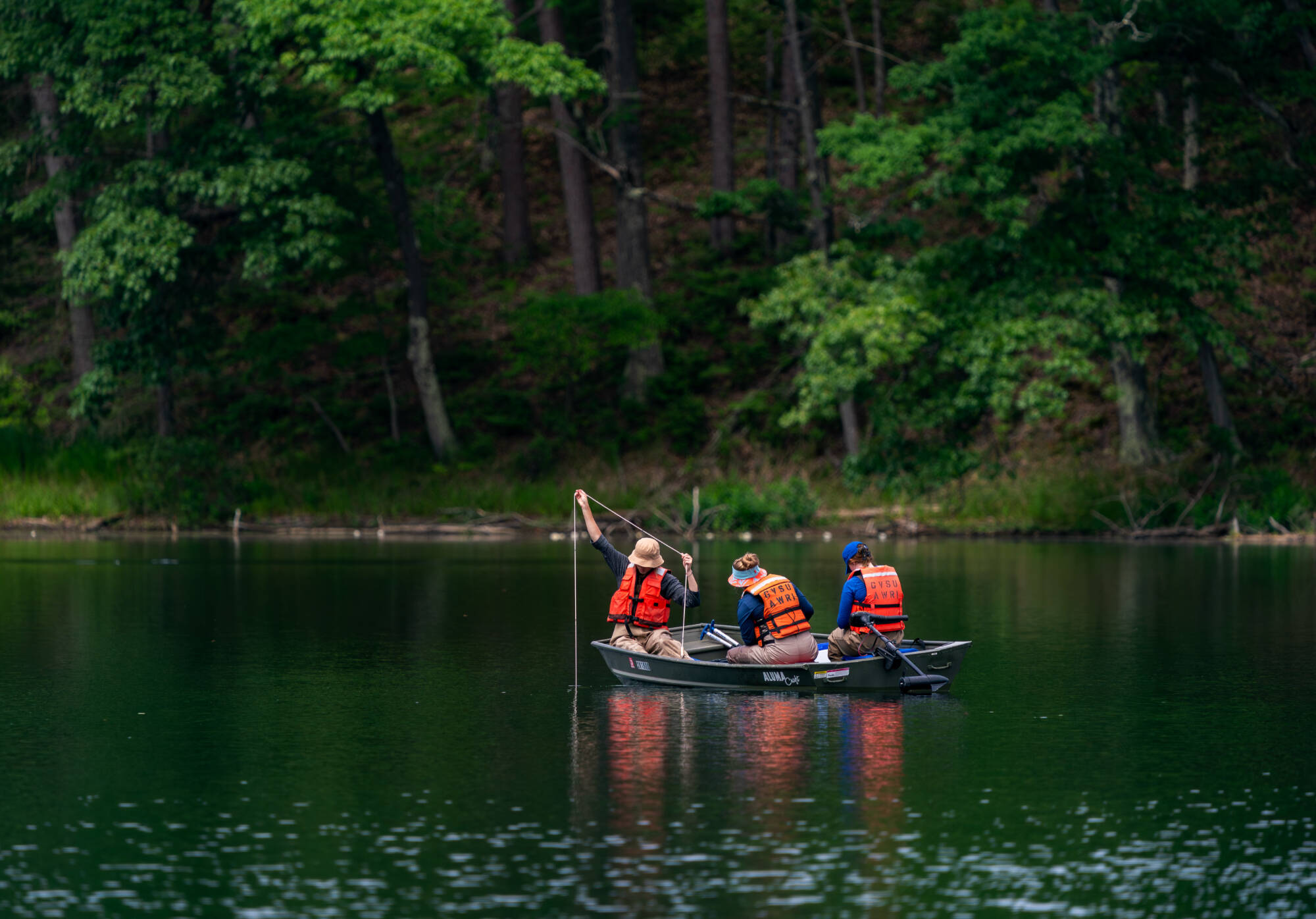 (From left) Mya Harmer, Katie Tyrrell and Alexis Porter, staff members with the Steinman Lab, collect samples on Highbank Lake in Newaygo County on June 24. They are working as part of AWRI’s inland lake salt survey. (Photo releases on file)